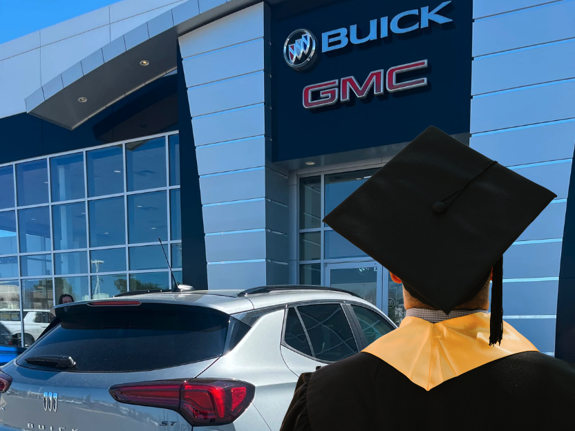 Graduate in cap and gown looking at a Buick SUV parked in front of Crain Buick GMC in Conway, Arkansas